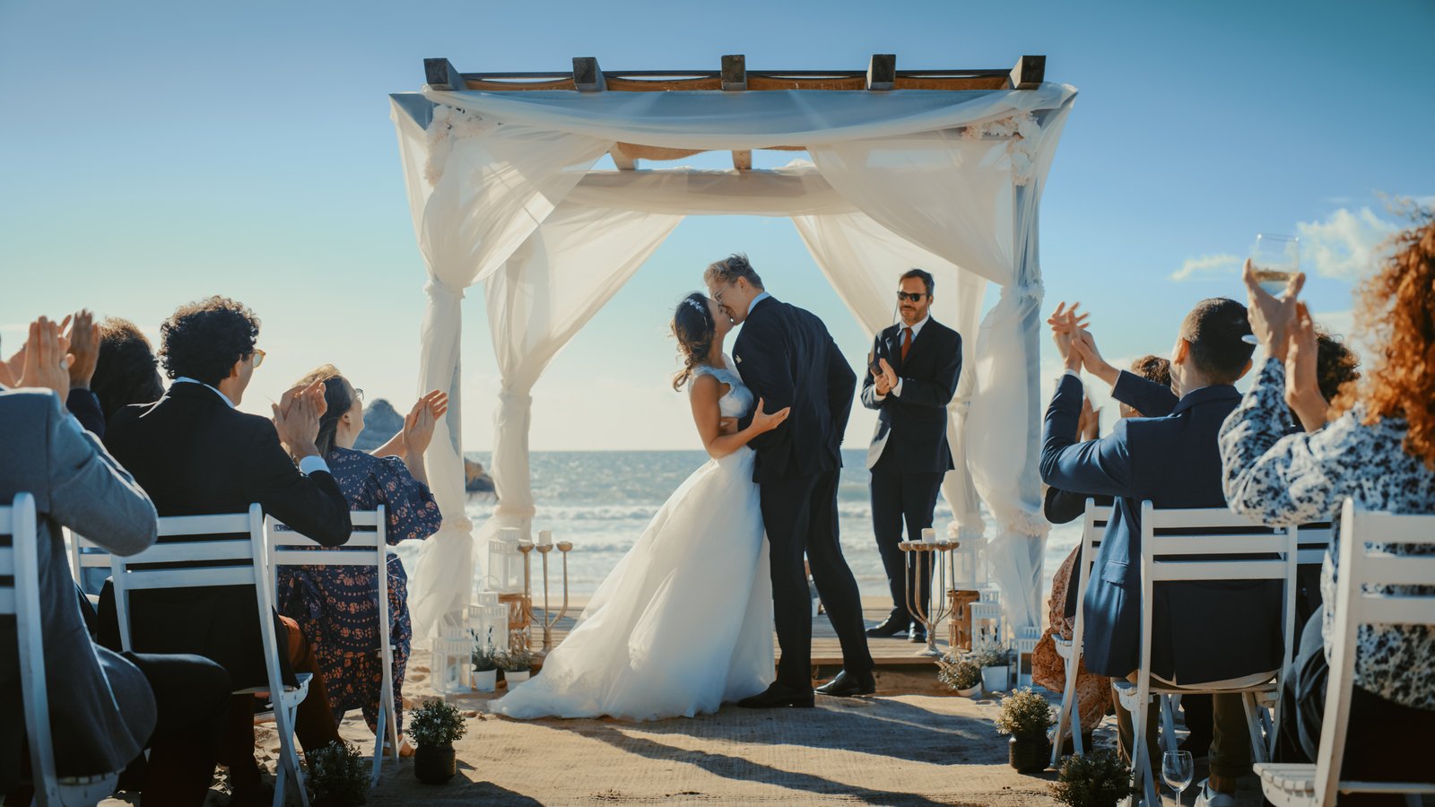 Beach wedding ceremony with guests applauding